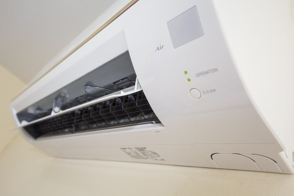 Split system air conditioner installed on an interior wall